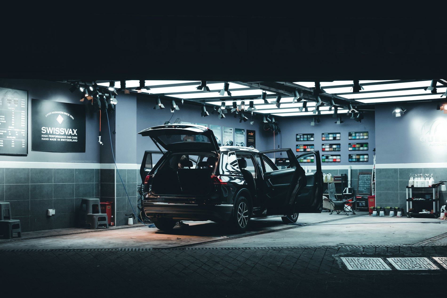 Officina illuminata di sera con un'auto in lavorazione